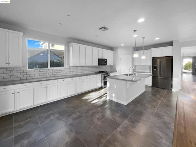 kitchen featuring appliances with stainless steel finishes, a kitchen island with sink, pendant lighting, and white cabinets