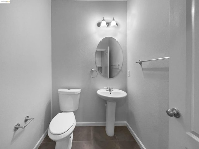 bathroom featuring sink, tile patterned floors, and toilet