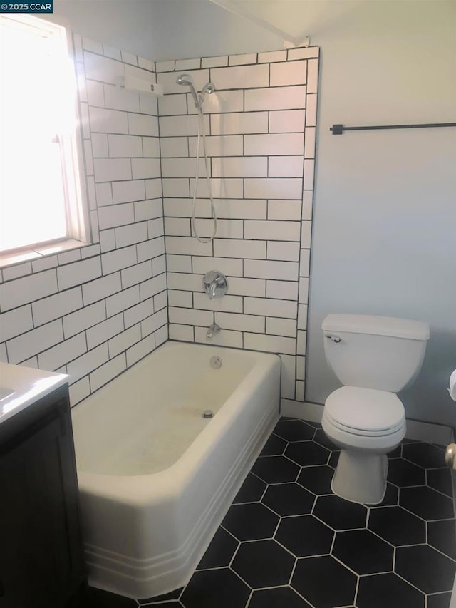 full bathroom featuring tile patterned flooring, vanity, toilet, and tiled shower / bath