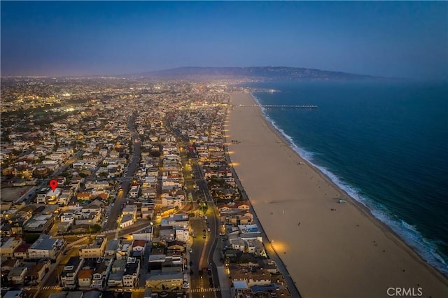 aerial view at dusk with a beach view and a water view