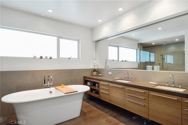 bathroom featuring vanity, separate shower and tub, a wealth of natural light, and tile walls