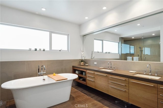 bathroom with a freestanding bath, a shower stall, double vanity, and a sink