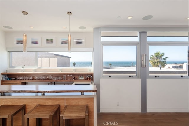 kitchen with decorative light fixtures, plenty of natural light, and a water view