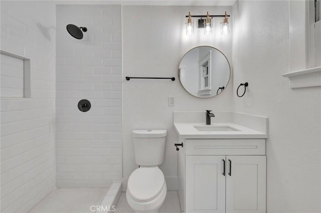 bathroom with vanity, toilet, and a tile shower