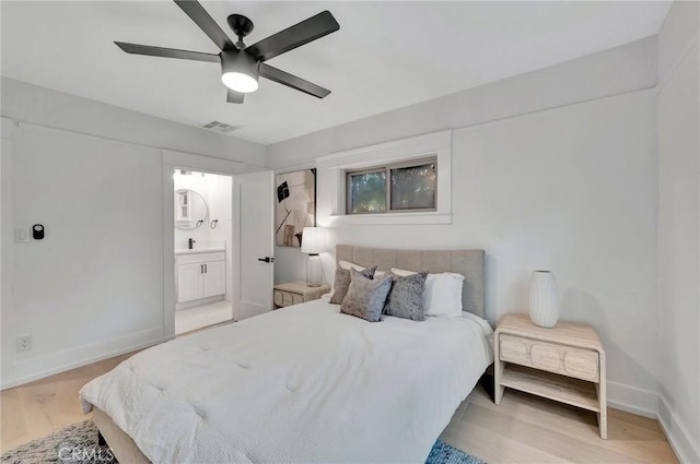 bedroom with connected bathroom, light hardwood / wood-style floors, and ceiling fan