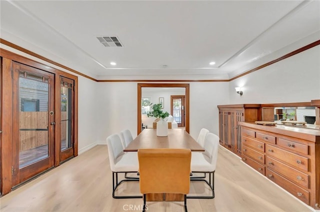 dining space with ornamental molding and light hardwood / wood-style floors