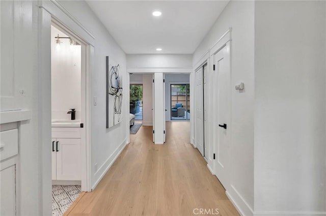 hall featuring sink and light hardwood / wood-style flooring