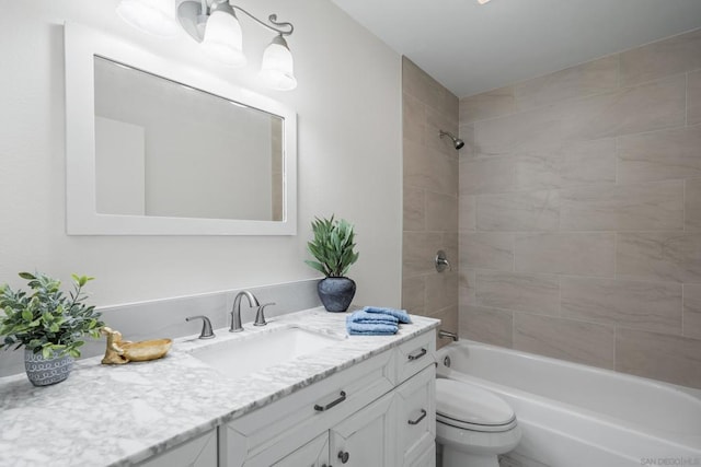 full bathroom with tiled shower / bath, vanity, and toilet