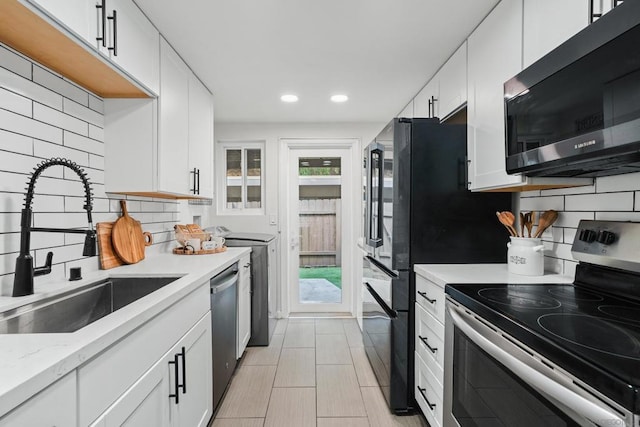 kitchen with white cabinetry, appliances with stainless steel finishes, sink, and decorative backsplash