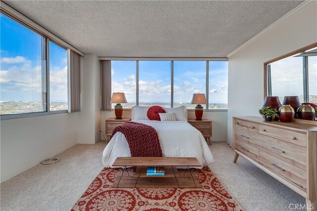 bedroom featuring light colored carpet, a textured ceiling, and ornamental molding