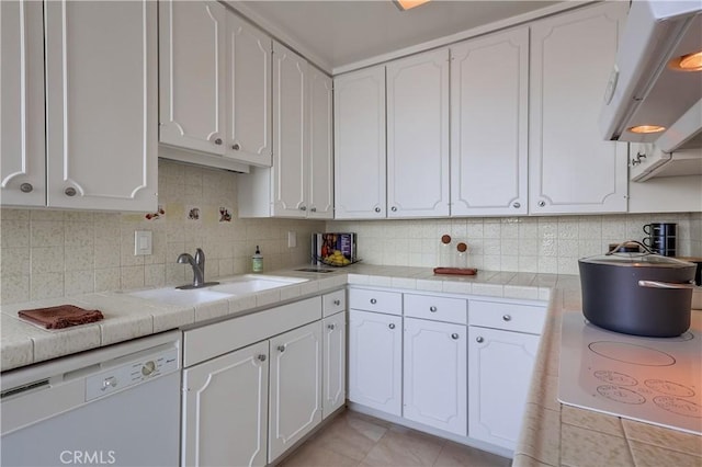 kitchen featuring white appliances, range hood, a sink, decorative backsplash, and white cabinets