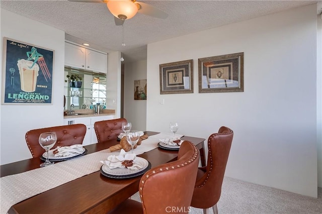 dining area featuring a textured ceiling, ceiling fan, and carpet flooring