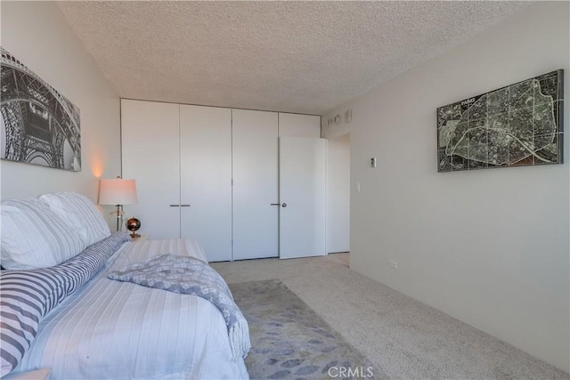 bedroom with a closet, carpet floors, and a textured ceiling