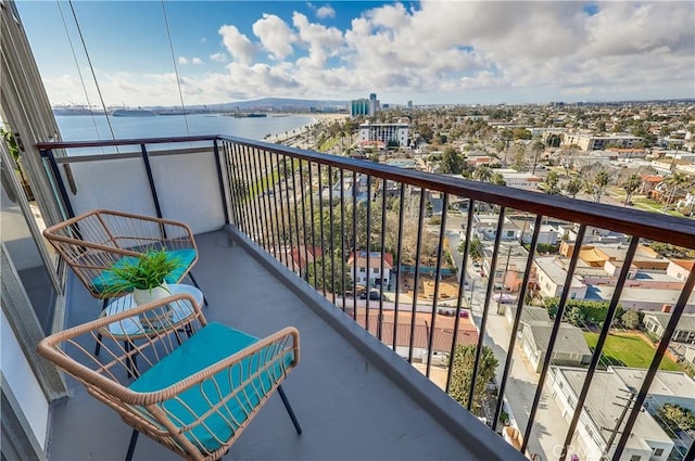 balcony with a water view and a view of city