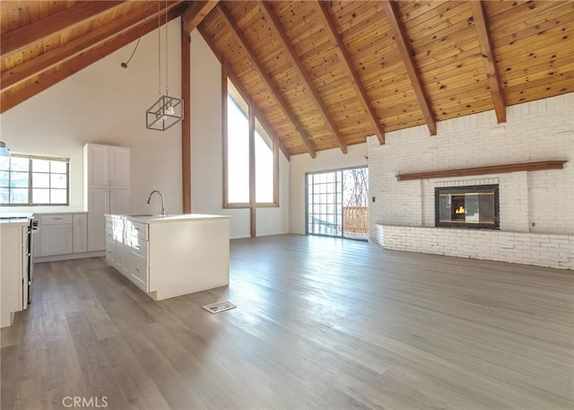 unfurnished living room featuring dark hardwood / wood-style flooring, wooden ceiling, and high vaulted ceiling