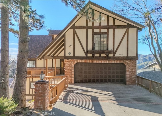 tudor-style house with a garage and a mountain view