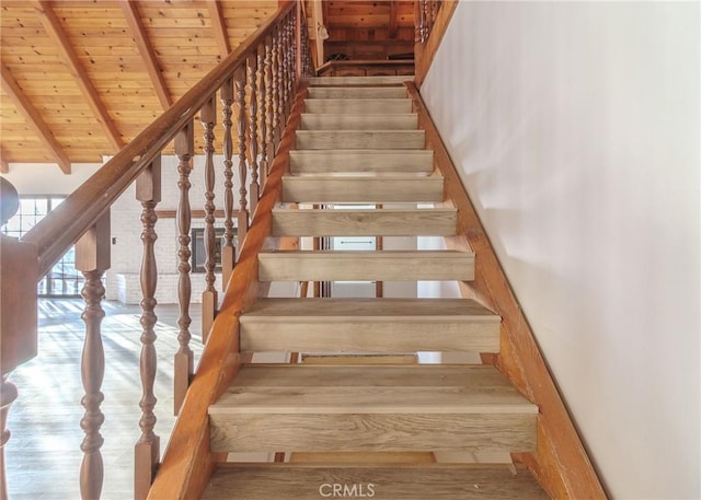 staircase featuring vaulted ceiling with beams, hardwood / wood-style floors, and wooden ceiling