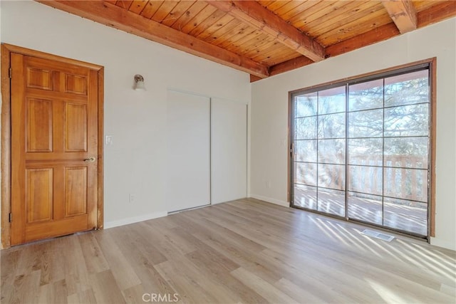 spare room with beam ceiling, wood ceiling, and light hardwood / wood-style flooring