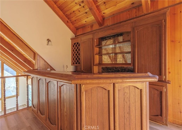 bar featuring lofted ceiling with beams, wooden ceiling, and light hardwood / wood-style floors