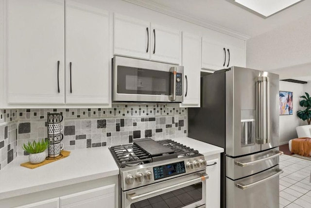 kitchen featuring stainless steel appliances, white cabinetry, light tile patterned floors, and decorative backsplash