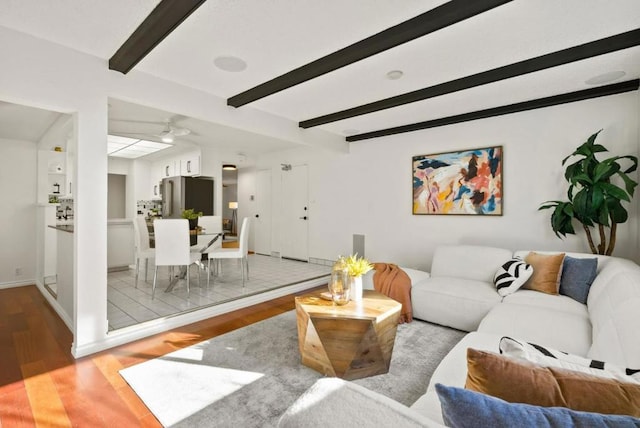 living room featuring beam ceiling and light hardwood / wood-style floors