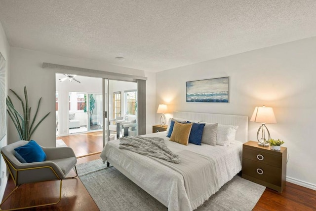 bedroom with dark wood-type flooring, access to exterior, and a textured ceiling