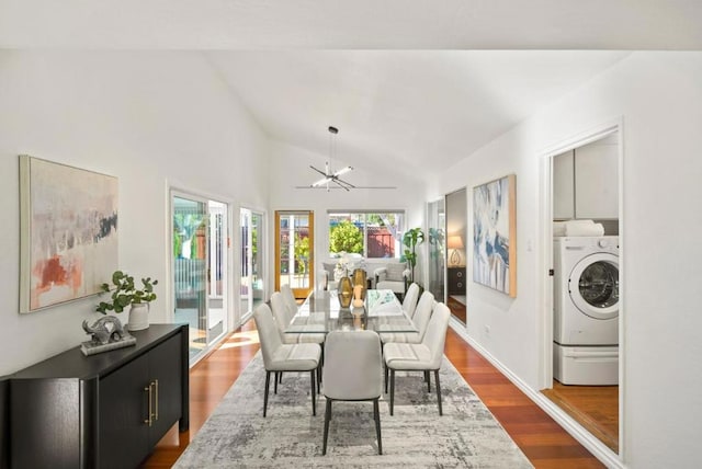 dining area with washer / dryer, a chandelier, lofted ceiling, and dark hardwood / wood-style flooring