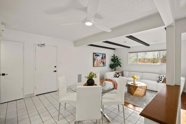 dining room featuring beamed ceiling, ceiling fan, a textured ceiling, and light tile patterned floors