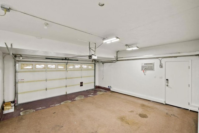 garage with a garage door opener and an AC wall unit