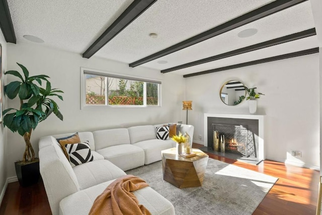 living room featuring beam ceiling, hardwood / wood-style floors, and a textured ceiling