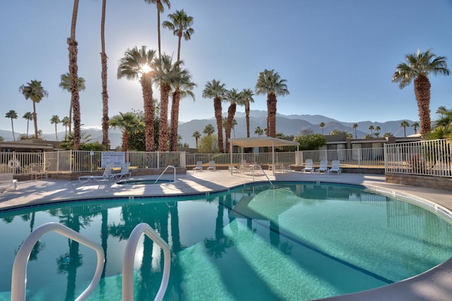 view of swimming pool with a mountain view and a patio area