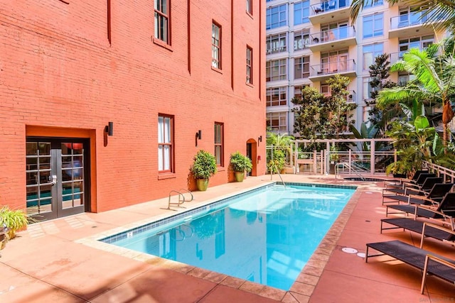 view of swimming pool with a patio and french doors