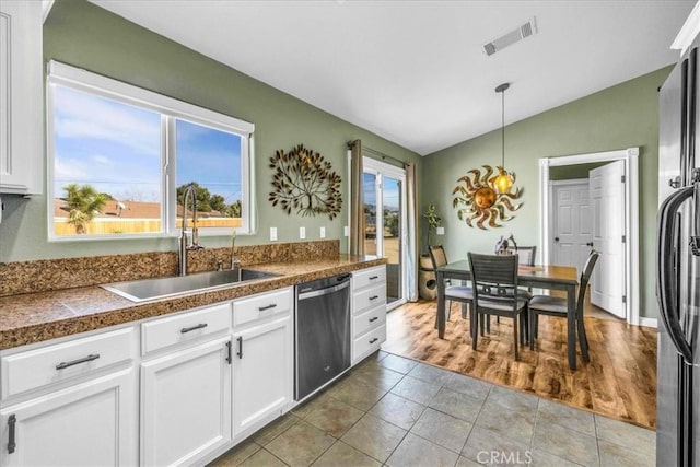 kitchen featuring sink, white cabinetry, decorative light fixtures, vaulted ceiling, and stainless steel appliances