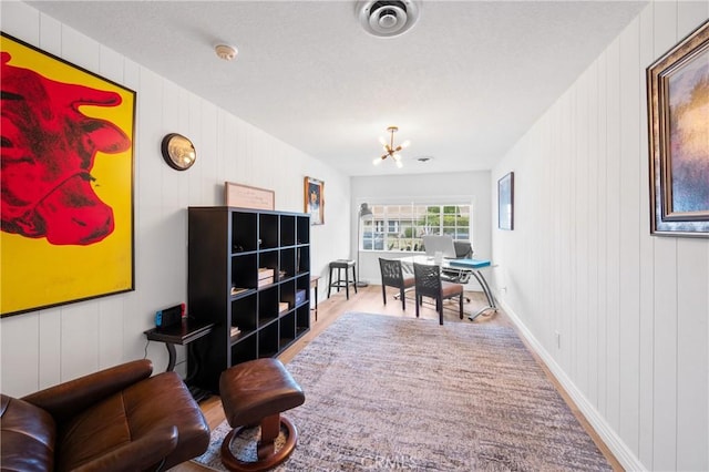 office area featuring a notable chandelier and light wood-type flooring