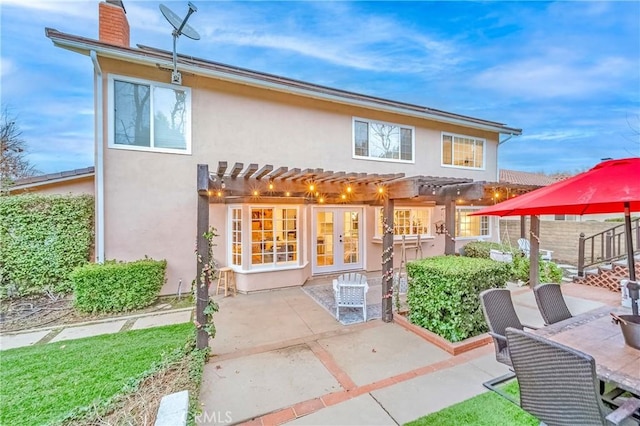 rear view of house with french doors, a patio area, and a pergola