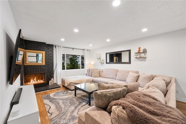 living room featuring hardwood / wood-style floors and a brick fireplace