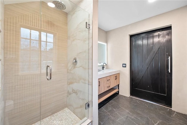 bathroom featuring a shower with door and vanity