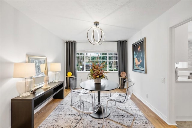 dining space with an inviting chandelier and light hardwood / wood-style floors