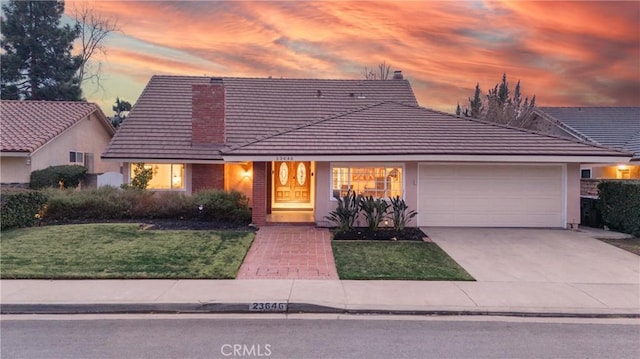 view of front of house featuring a garage and a yard