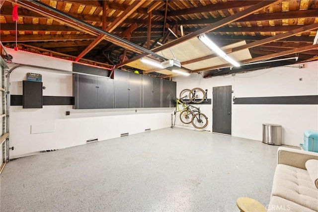 garage with a garage door opener and electric panel