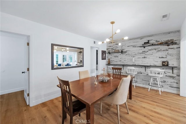 dining room with a chandelier and light wood-type flooring