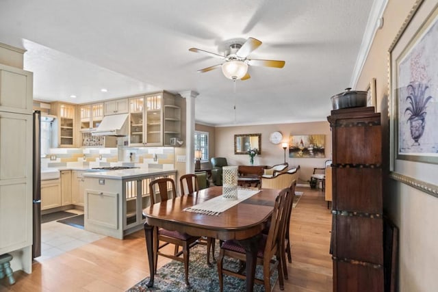 dining space with ceiling fan, ornamental molding, and light hardwood / wood-style flooring