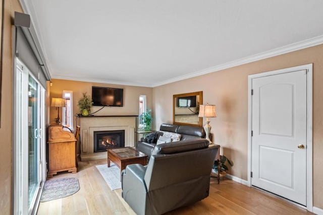 living room featuring crown molding, plenty of natural light, and light wood-type flooring