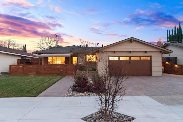 ranch-style home featuring a garage and a yard