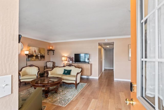 living room with ornamental molding and light hardwood / wood-style flooring