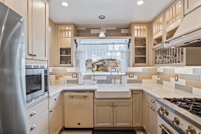 kitchen featuring pendant lighting, sink, stainless steel appliances, extractor fan, and decorative backsplash