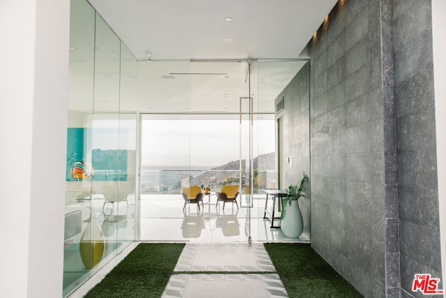 bathroom featuring a wall of windows and tile patterned flooring