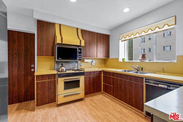 kitchen with sink, black dishwasher, range, and light hardwood / wood-style flooring