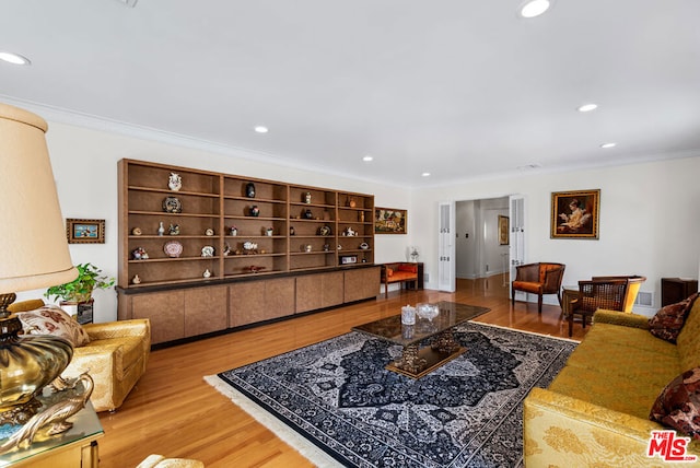 living room featuring crown molding and light hardwood / wood-style flooring