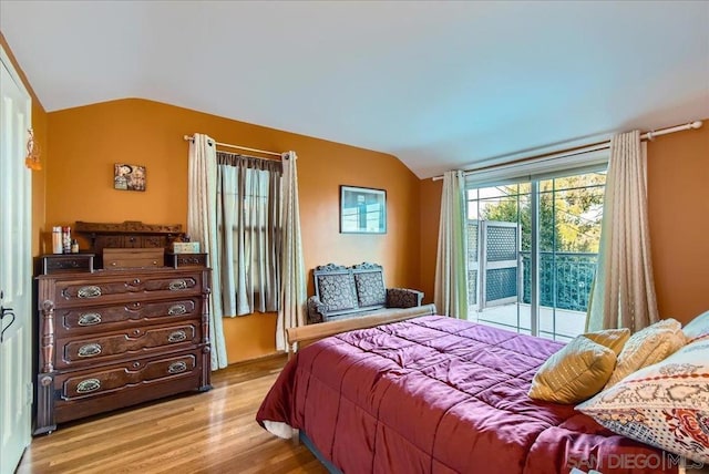 bedroom featuring vaulted ceiling, access to outside, and light hardwood / wood-style floors